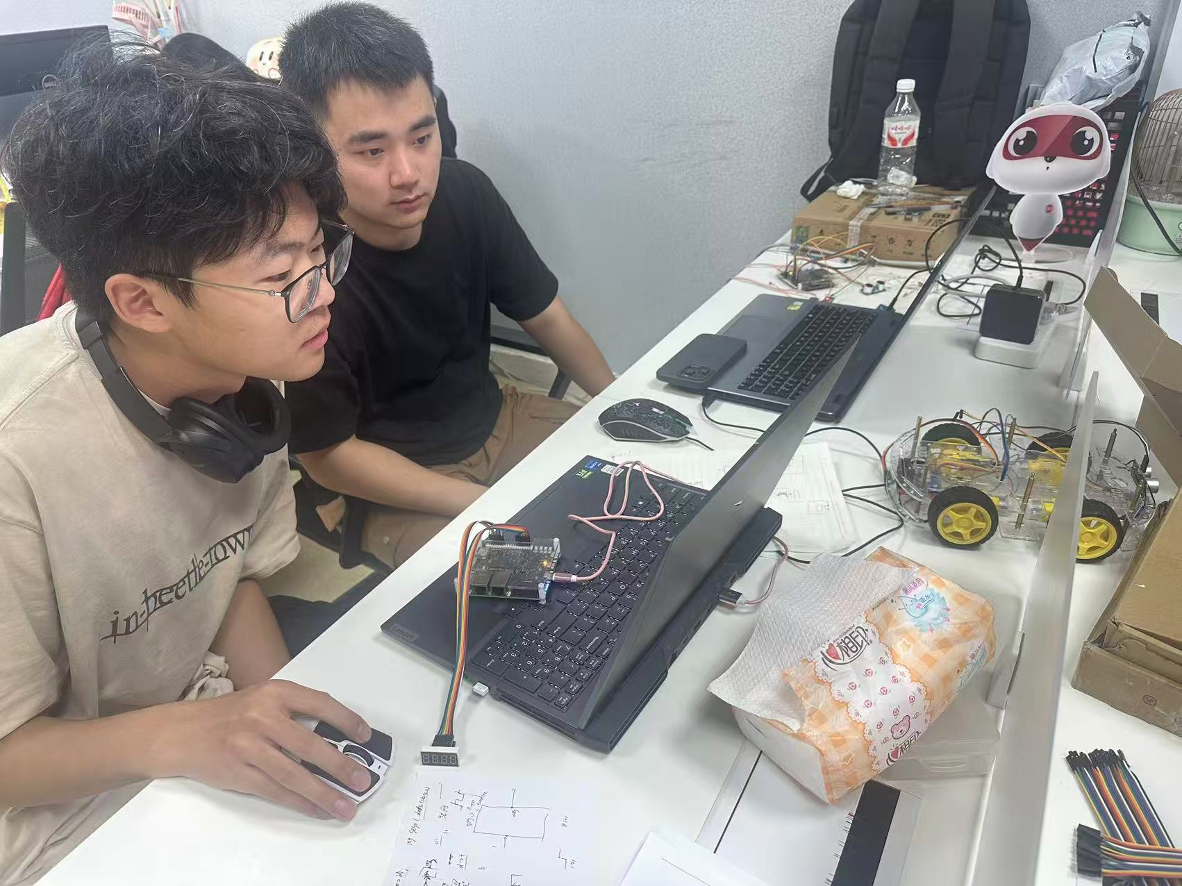 Students debugging hardware and optimizing circuit layout with engineer guidance